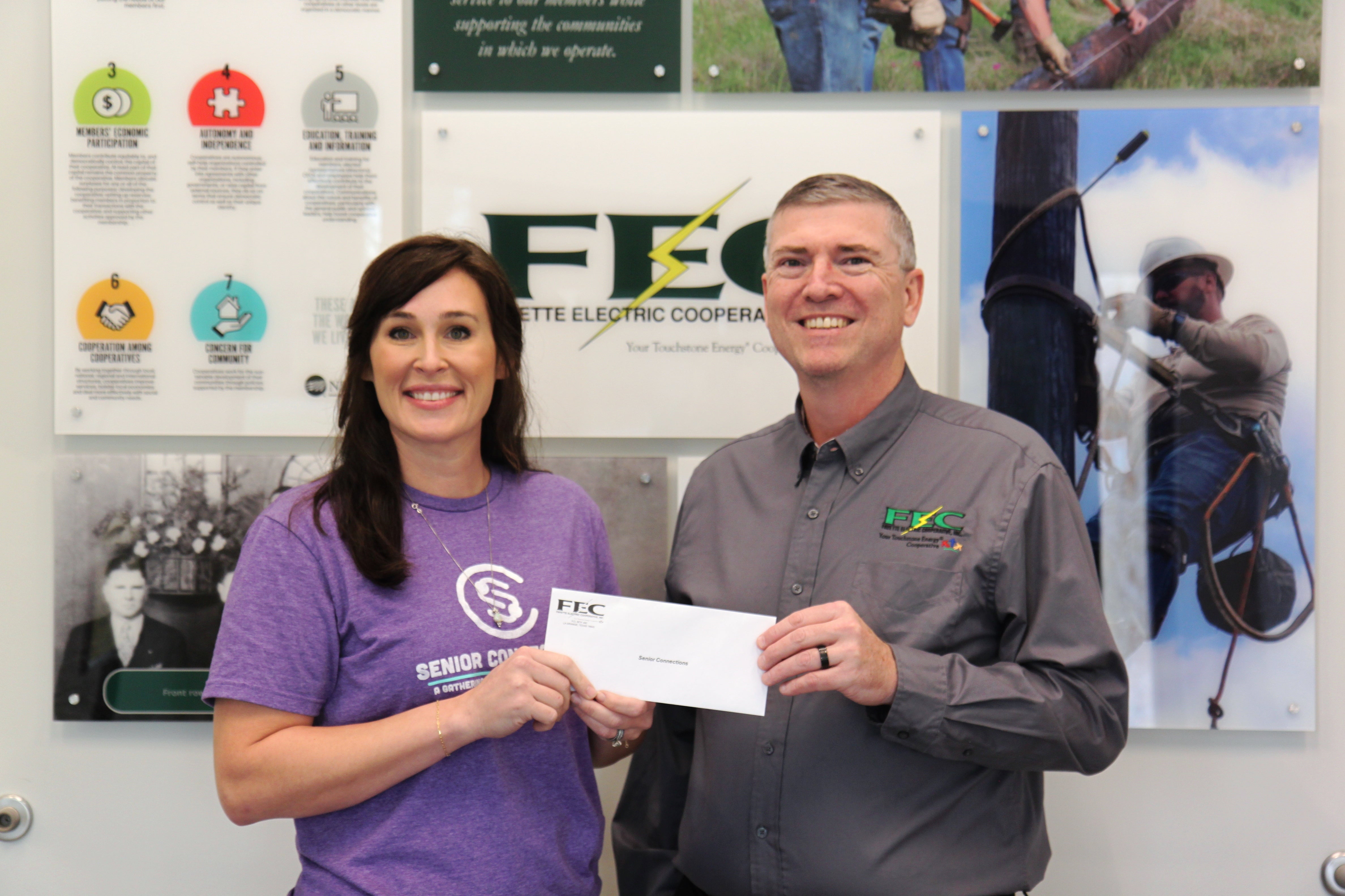 two people holding a check