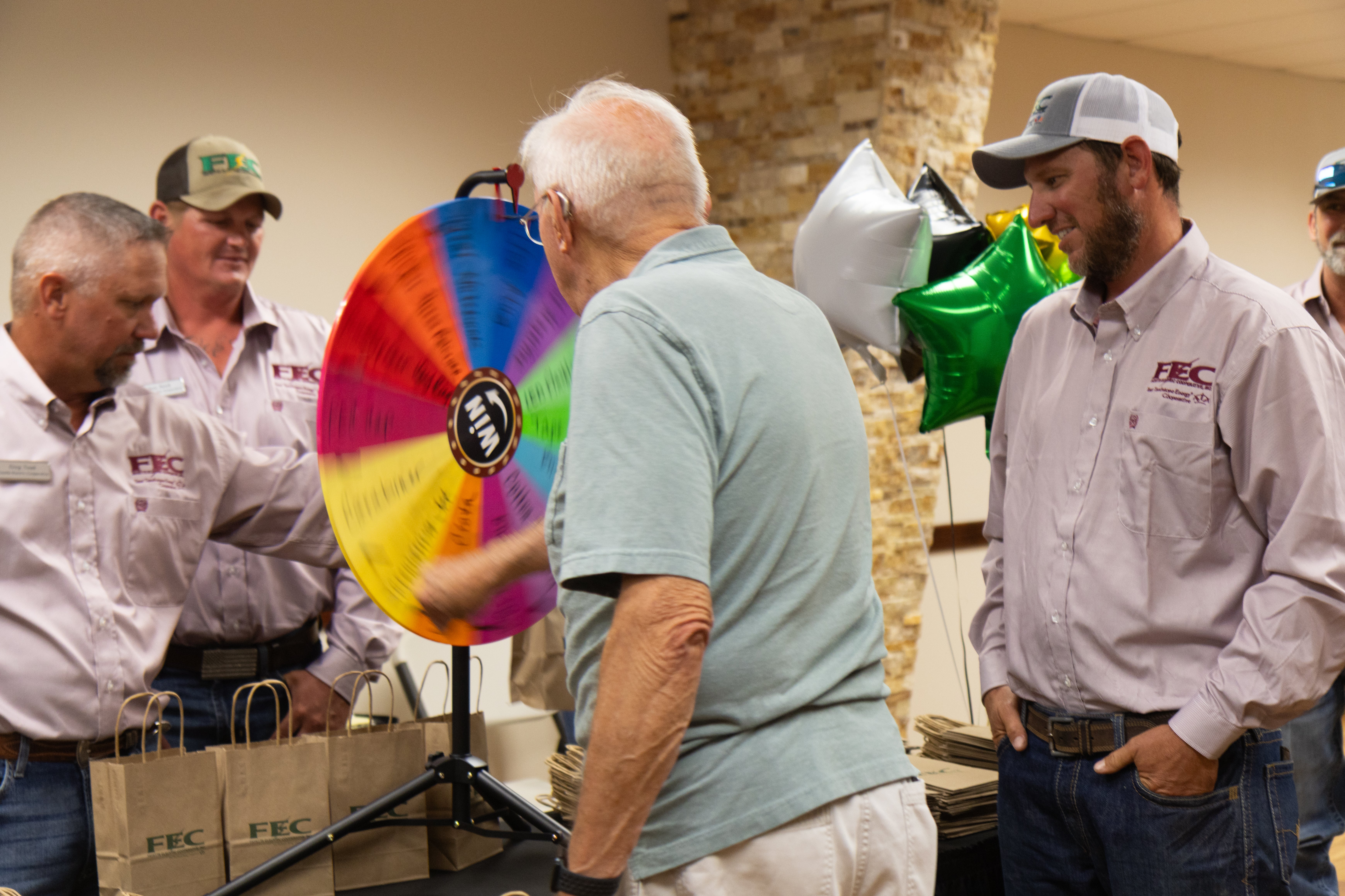 Before the meeting, attendees visited with employees and played games, such as this wheel of fortune-style game.
