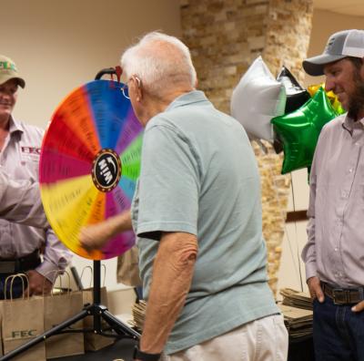 Before the meeting, attendees visited with employees and played games, such as this wheel of fortune-style game.